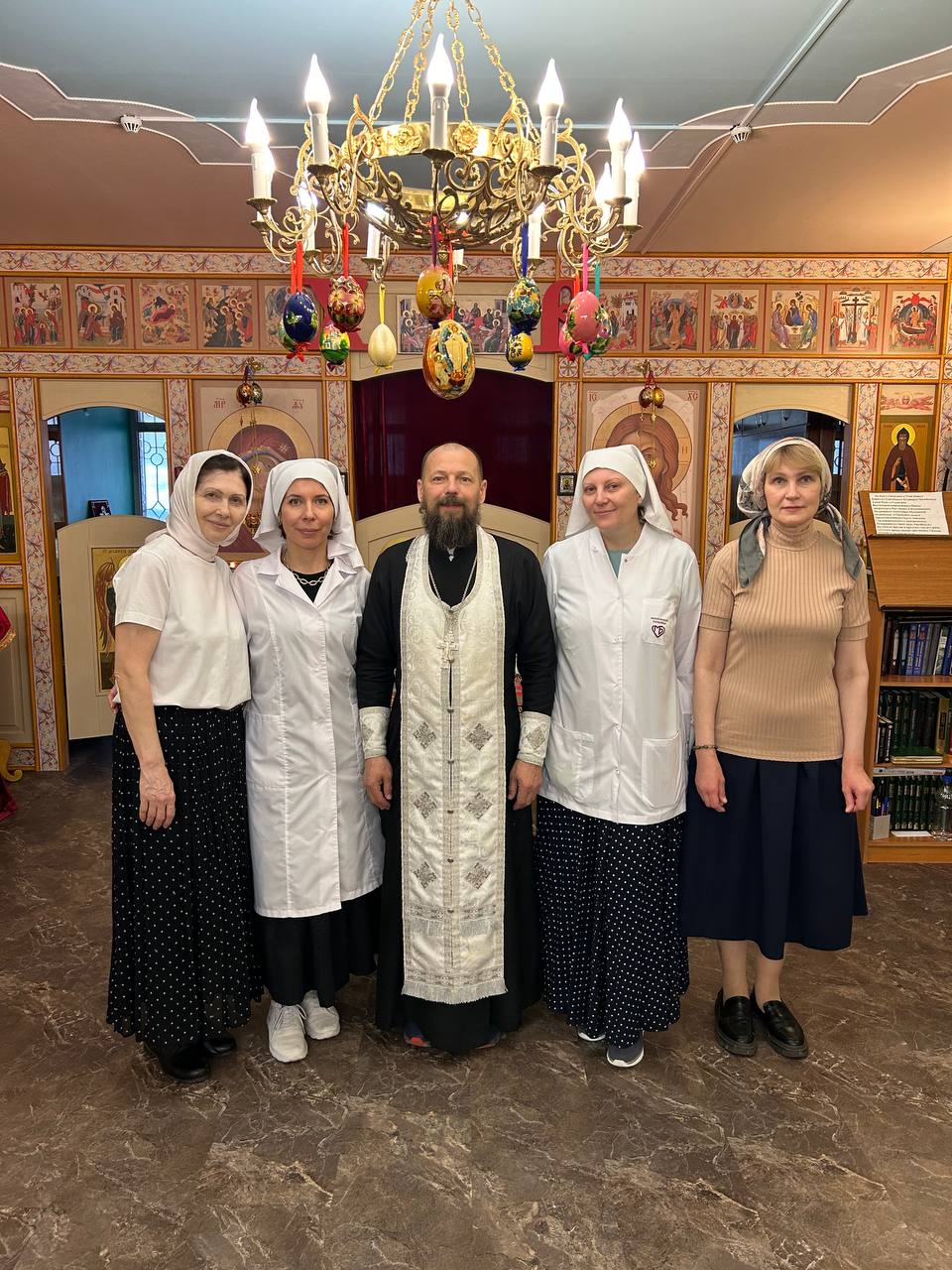 Сёстры милосердия со священником в храме